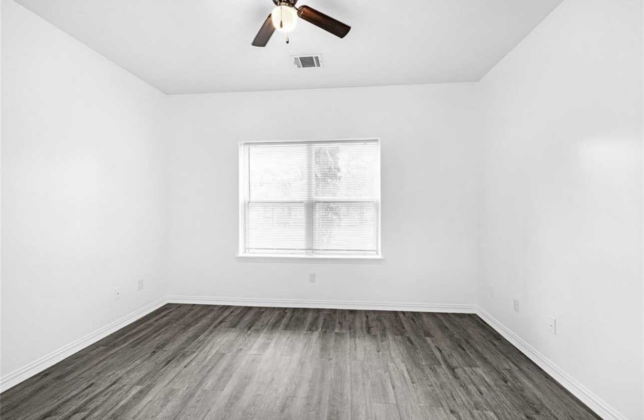 6122 West Mt Houston Road, Unit 4 Houston, TX 77088 - Photo 9 of 11 an empty room with a window and wooden floor