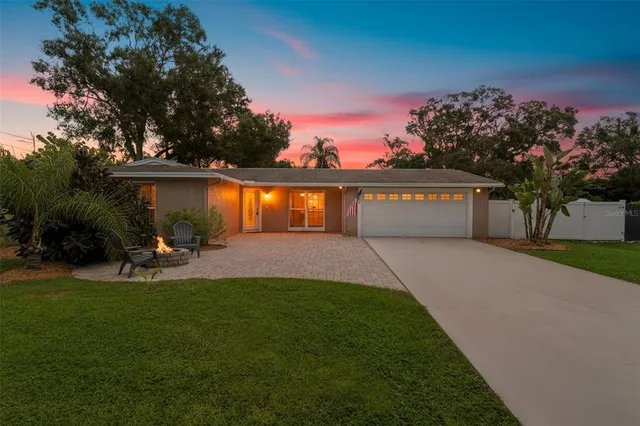 a view of a house with backyard and sitting area