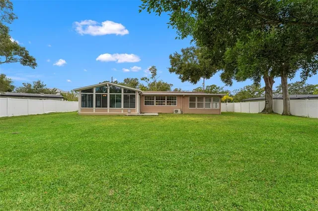 an aerial view of residential houses with outdoor space and trees