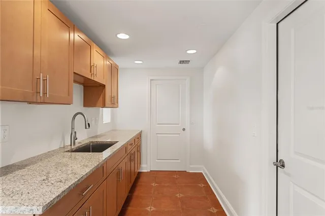 a kitchen with a sink a refrigerator and cabinets