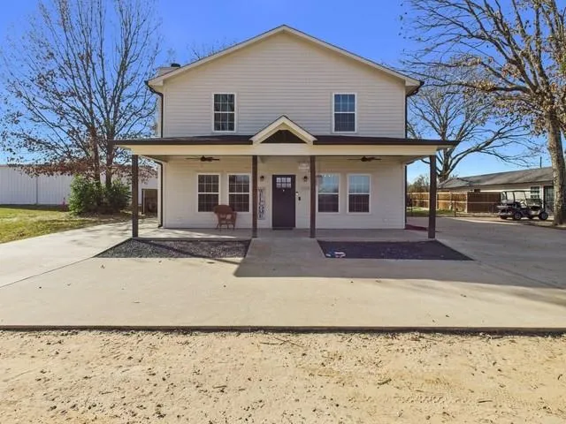 a view of a white house with a yard and large tree