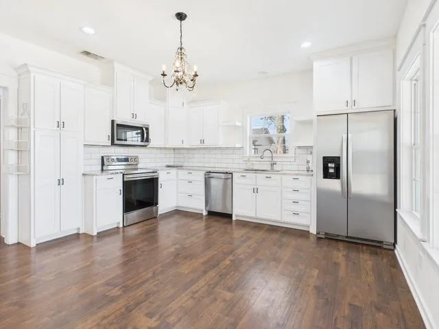 a kitchen with stainless steel appliances a refrigerator sink and cabinets