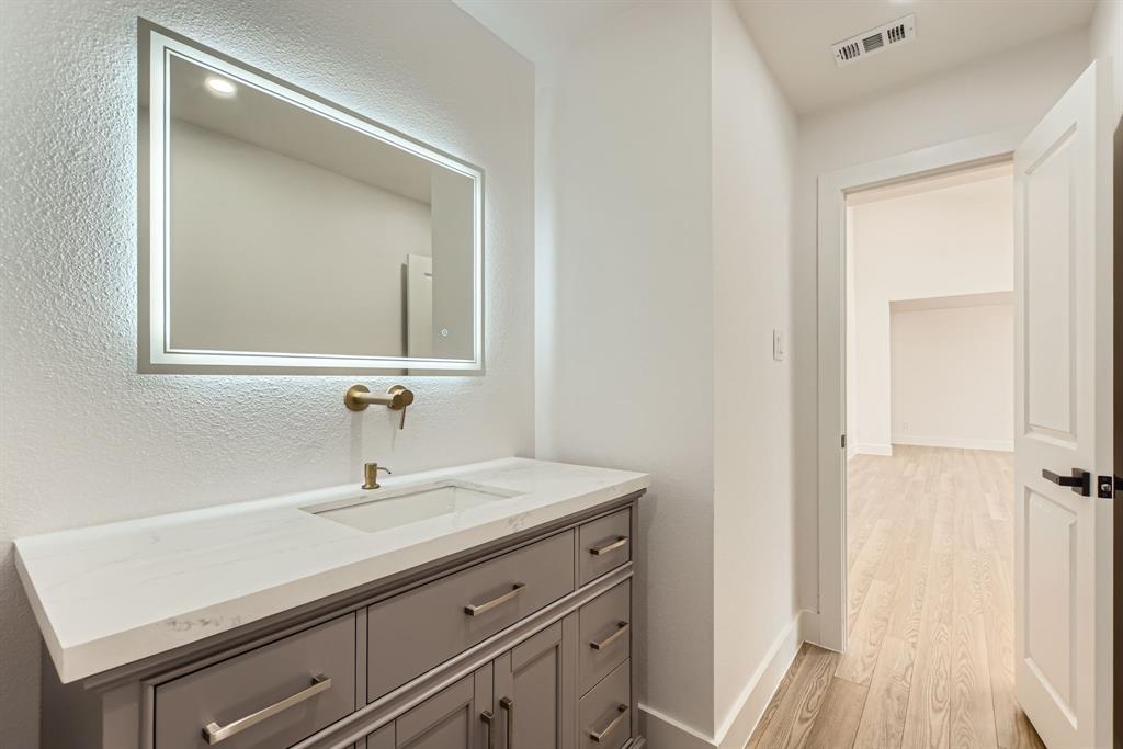 16212 Spring Creek Road Dallas, TX 75248 - Photo 14 of 27 a bathroom with a sink and a mirror