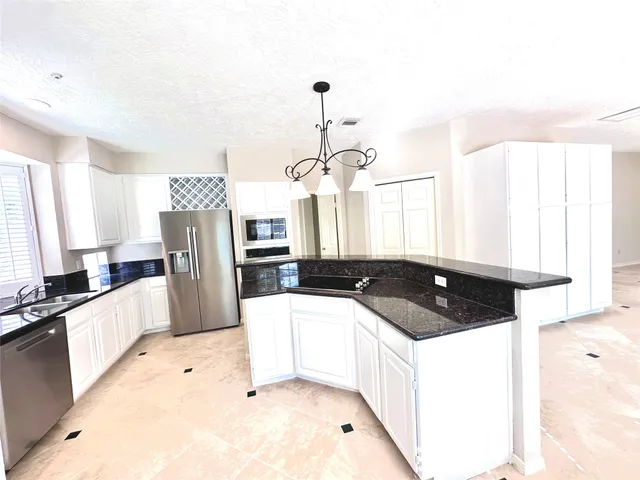 a view of an empty room with window and cabinet