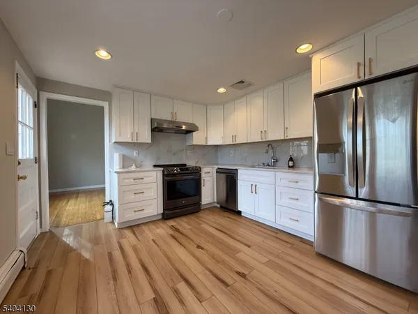 a kitchen with stainless steel appliances a refrigerator and a stove top oven