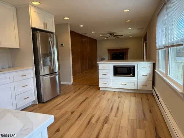 a view of kitchen with sink microwave refrigerator and cabinets