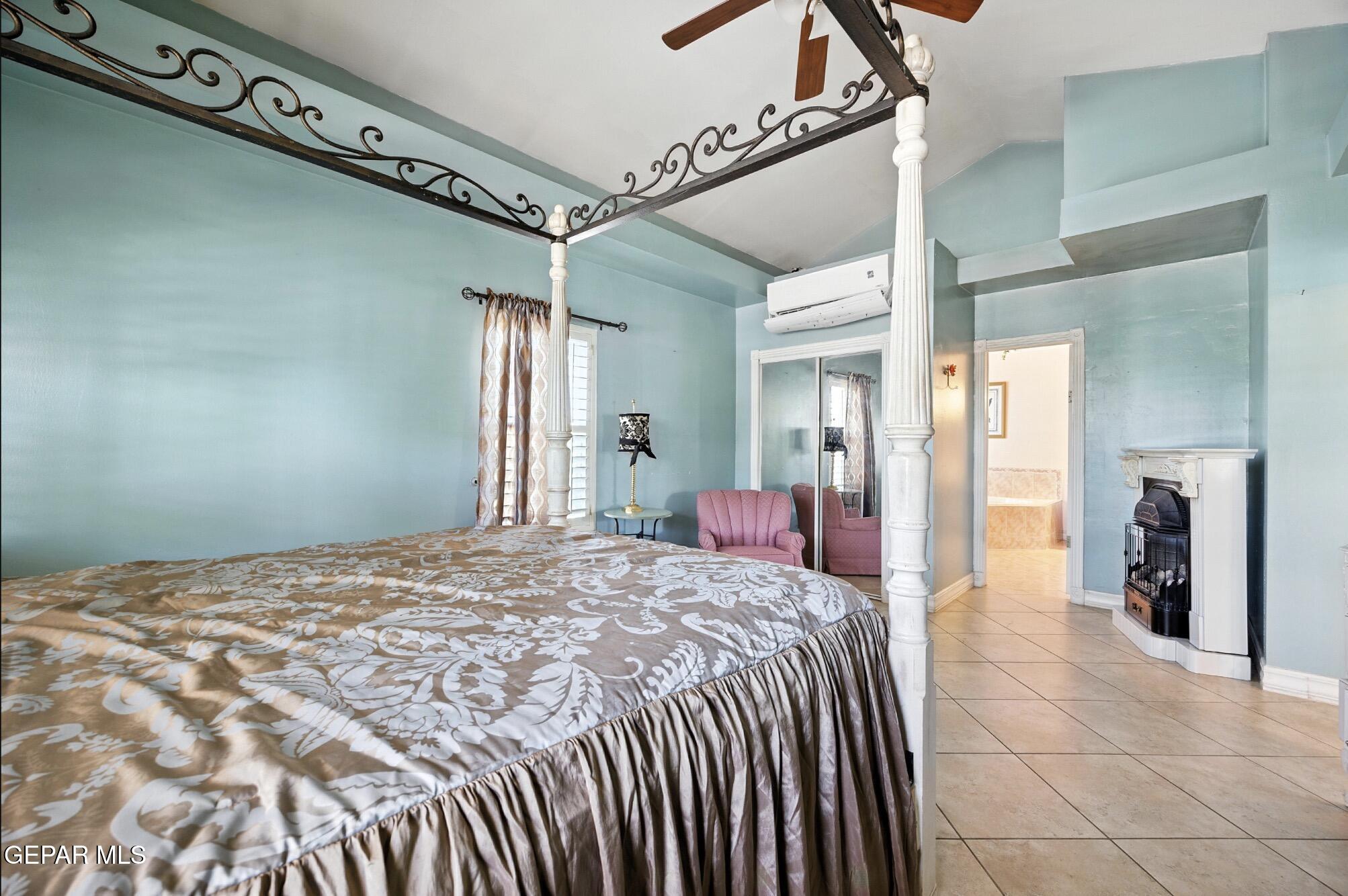 190 Polo Inn Road El Paso, TX 79915 - Photo 15 of 58 a bedroom with a large bed and a chandelier