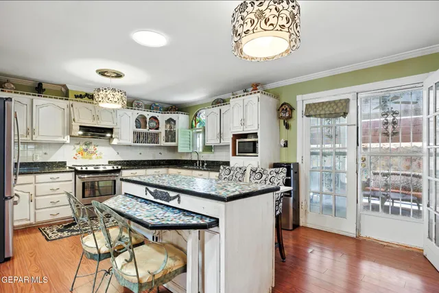 a kitchen with stainless steel appliances granite countertop a stove a sink and a microwave