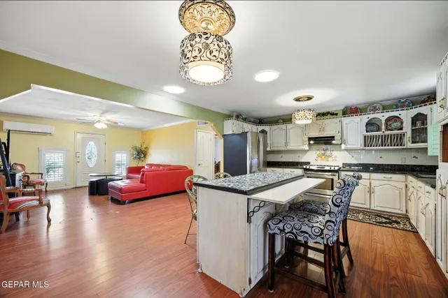 a kitchen with granite countertop a stove a sink and a microwave