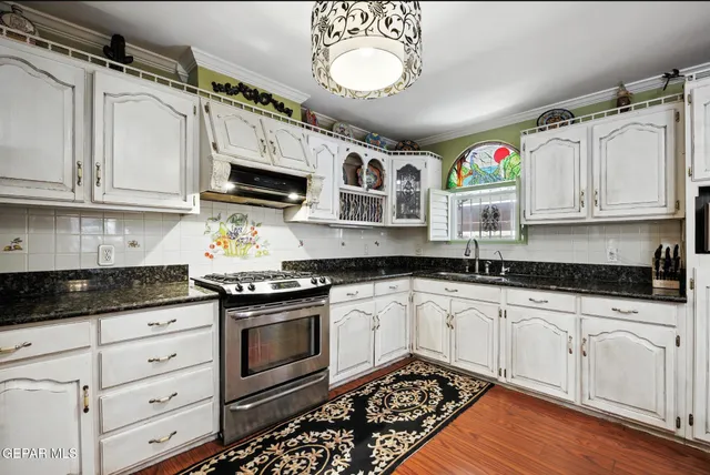 a kitchen with stainless steel appliances granite countertop a stove a sink and a microwave