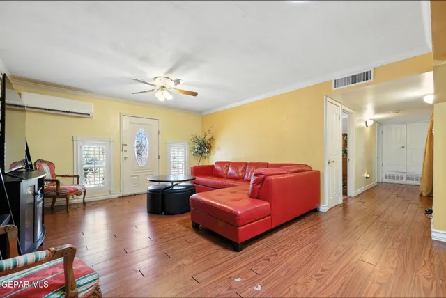 a living room with furniture and wooden floor