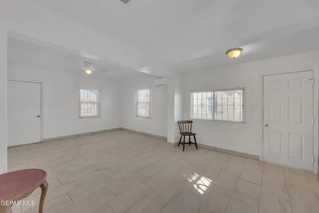 a kitchen with granite countertop a refrigerator stove and white cabinets