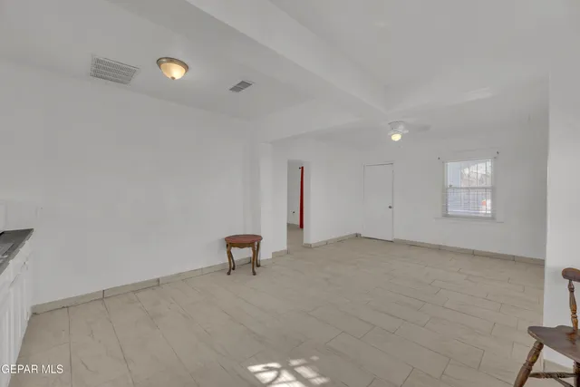 a kitchen with granite countertop white cabinets and window