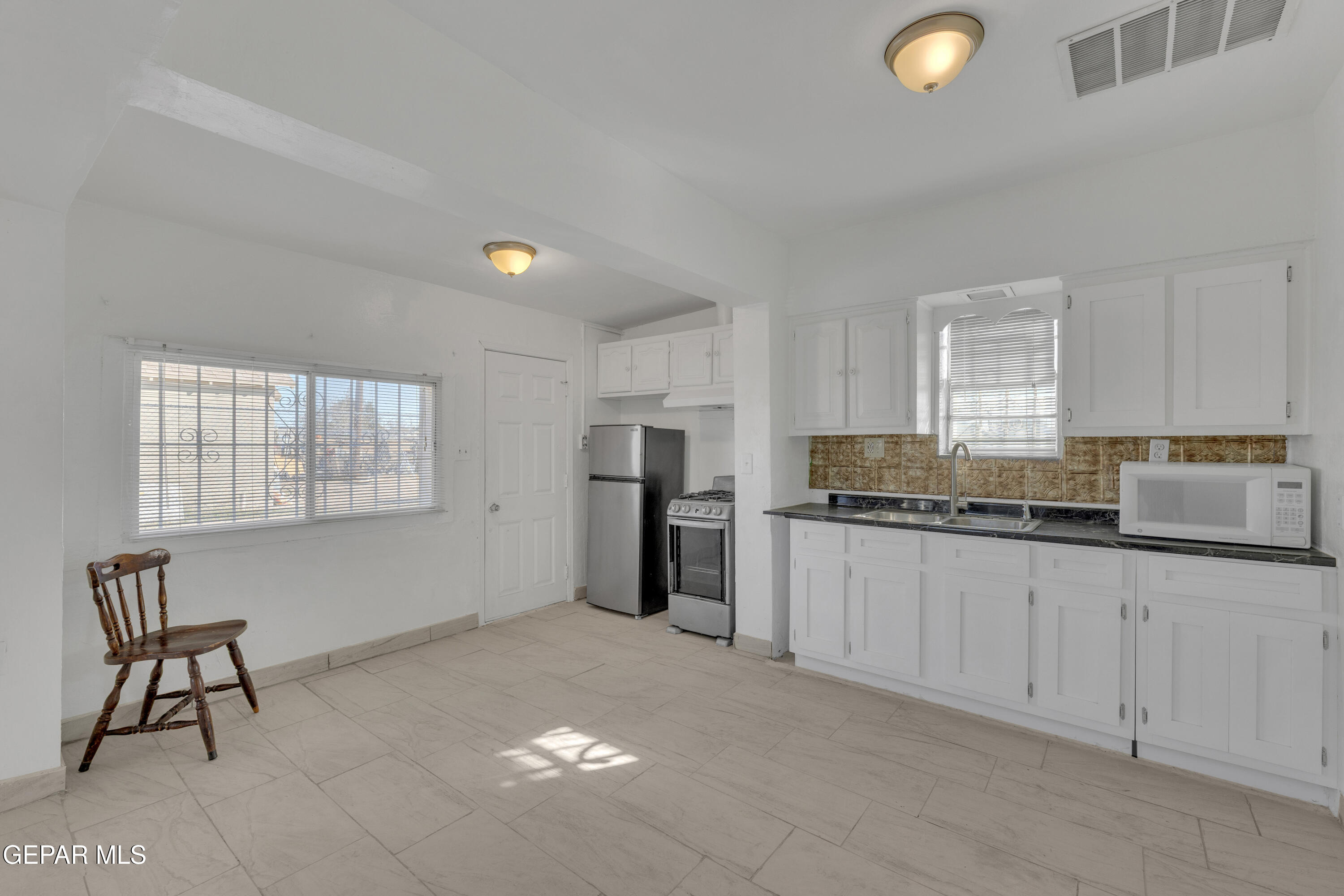 190 Polo Inn Road El Paso, TX 79915 - Photo 37 of 58 a kitchen with granite countertop white cabinets and window