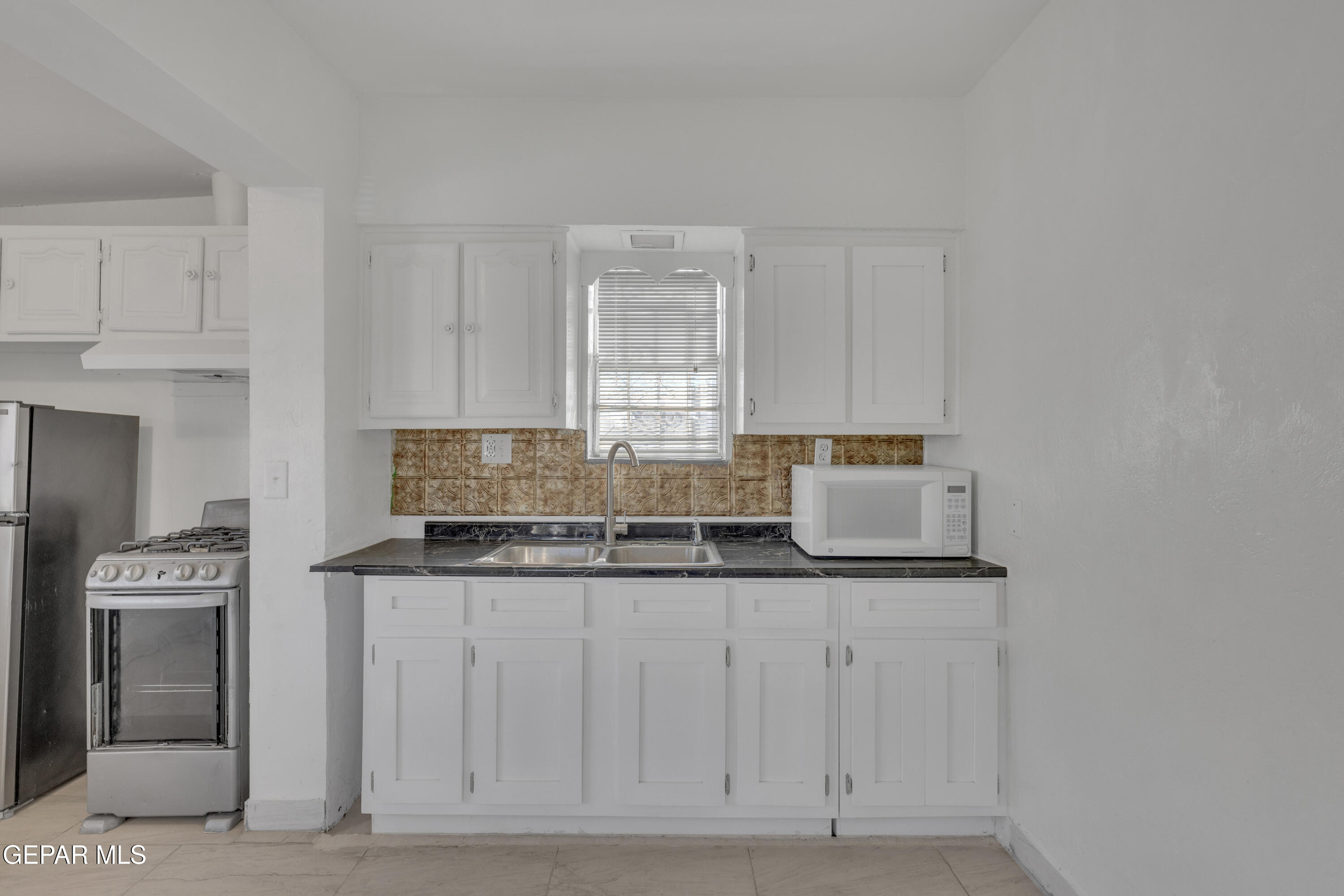 190 Polo Inn Road El Paso, TX 79915 - Photo 39 of 58 a kitchen with granite countertop a sink and a white cabinets