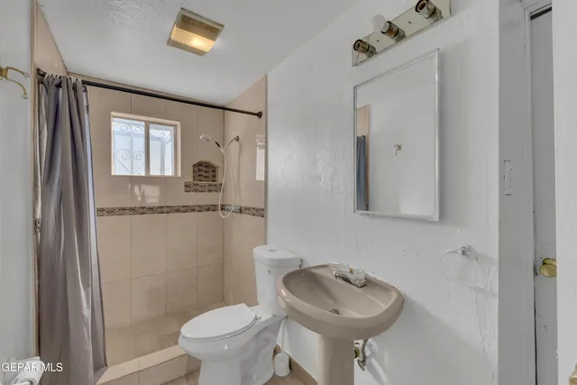 a bedroom with a bed mirror and a window