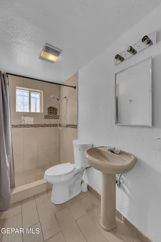 a view of a house with a small yard and wooden fence