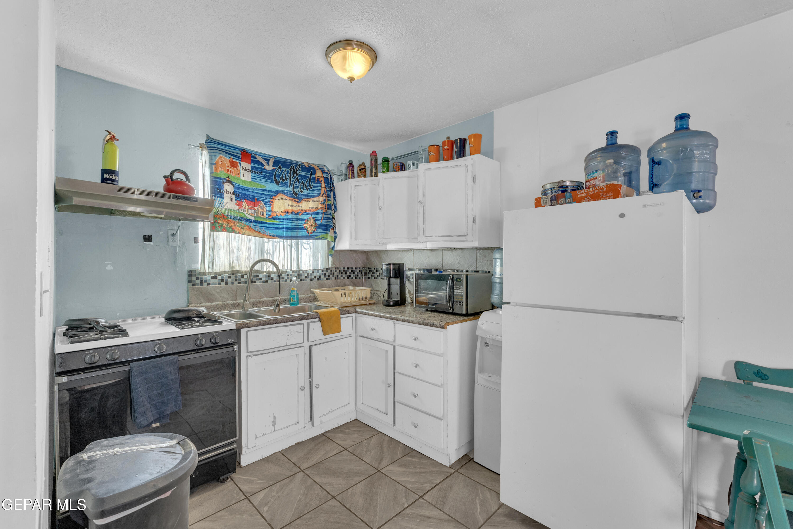 190 Polo Inn Road El Paso, TX 79915 - Photo 52 of 58 a kitchen with a sink a stove and white cabinets