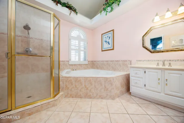 a spacious bathroom with a tub shower and mirror
