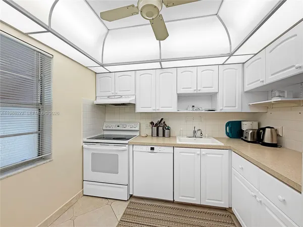 a kitchen with stainless steel appliances white cabinets and a refrigerator
