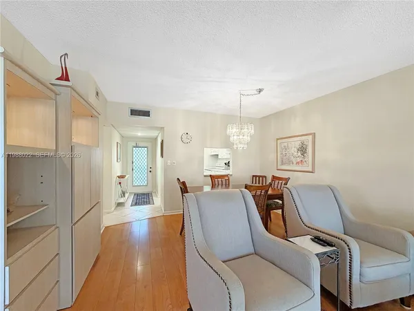 a living room with furniture and a large window with wooden floor