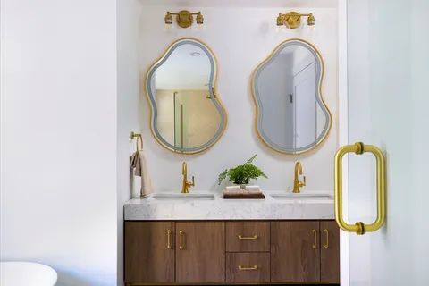 a bathroom with a granite countertop sink a mirror and a toilet