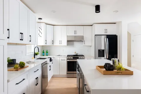 a kitchen with stainless steel appliances a stove a sink a refrigerator and cabinets
