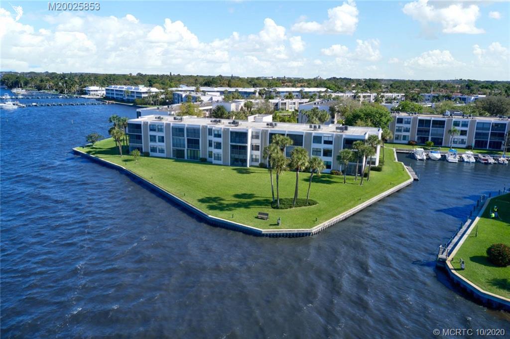 1950 Southwest Palm City Road, Unit 13305 Stuart, FL 34994 - Photo 1 of 28 a view of a swimming pool with lake and houses in the back