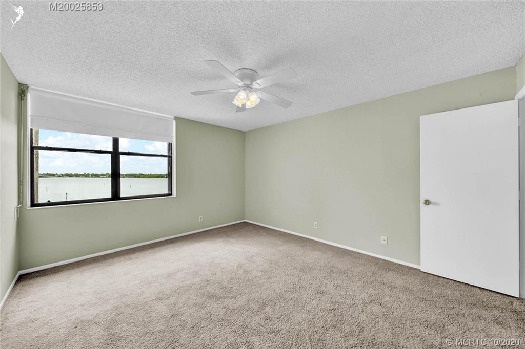 1950 Southwest Palm City Road, Unit 13305 Stuart, FL 34994 - Photo 17 of 28 an empty room with windows and ceiling fan