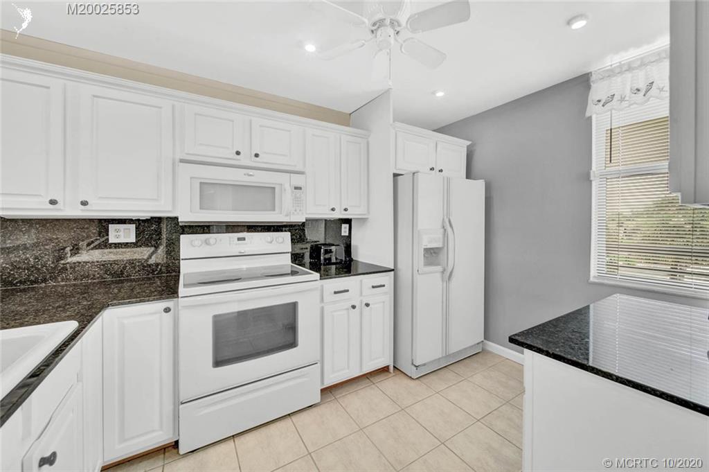 1950 Southwest Palm City Road, Unit 13305 Stuart, FL 34994 - Photo 8 of 28 a kitchen with white cabinets and white appliances