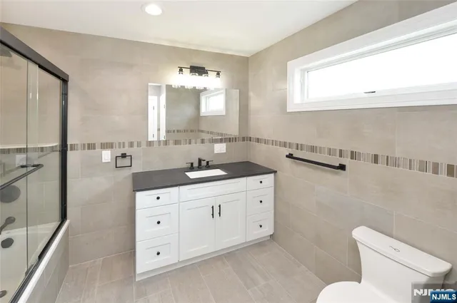 a bathroom with a double vanity sink a mirror and a toilet