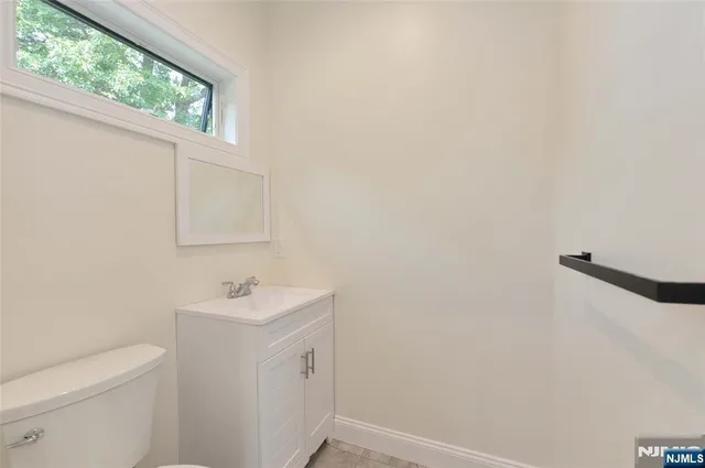 a bathroom with a sink a toilet and a window