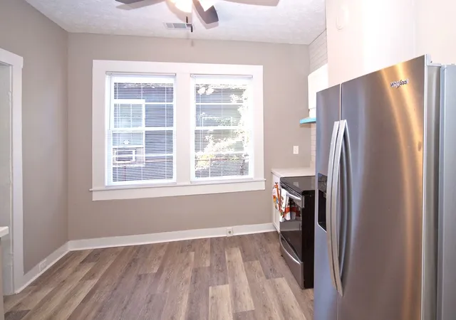 a view of empty room with a refrigerator and window