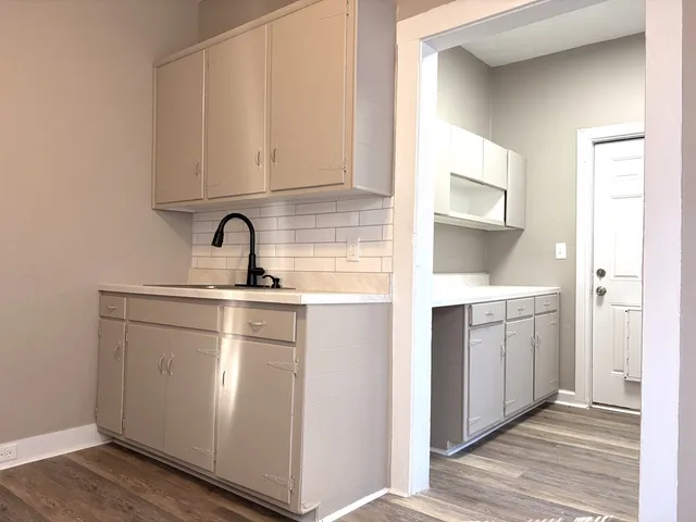 a kitchen with white cabinets and sink