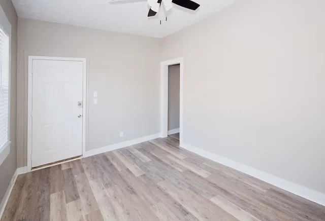a view of an empty room with wooden floor
