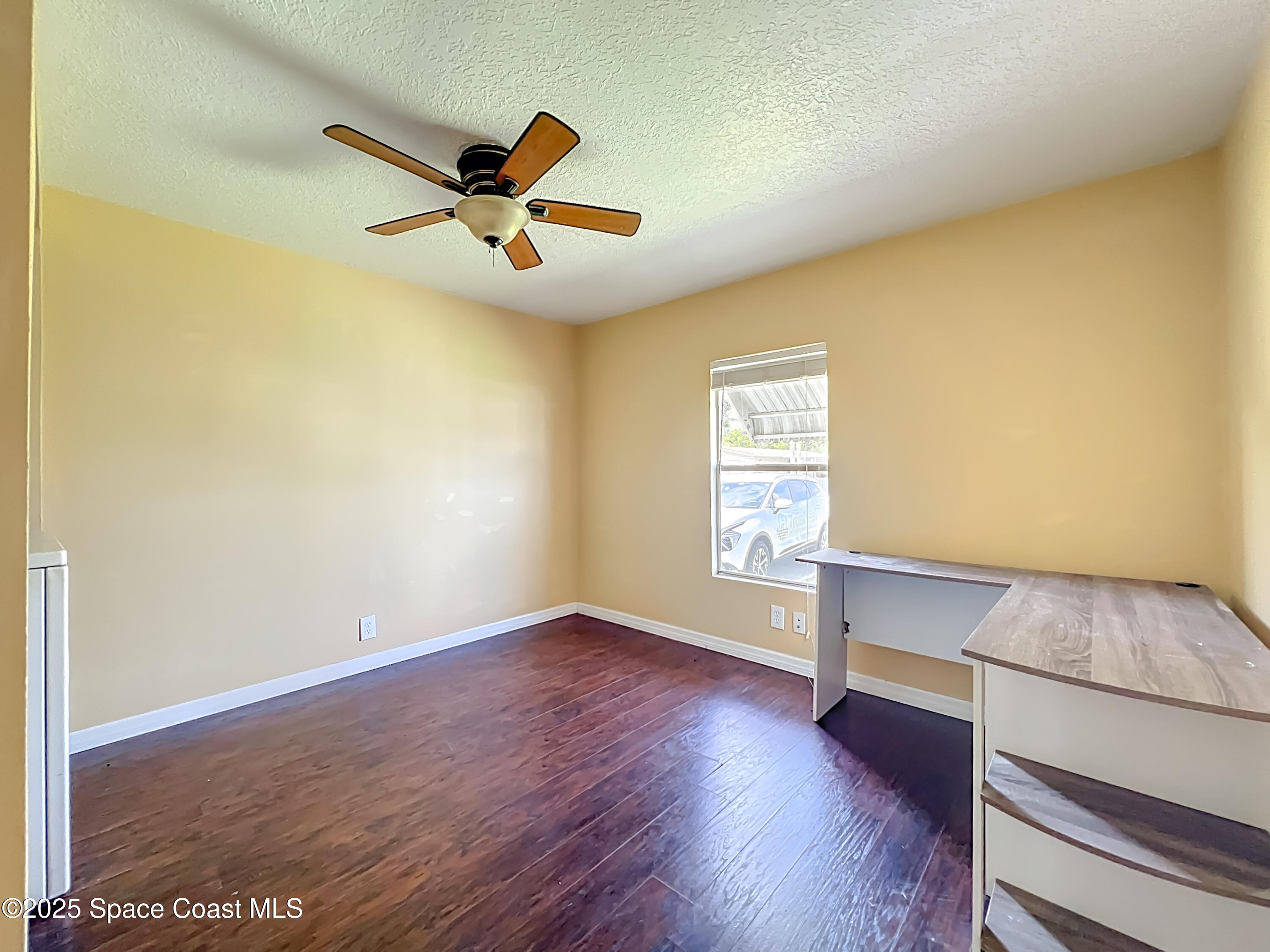 425 Baker Road Merritt Island, FL 32953 - Photo 12 of 27 an empty room with wooden floor and windows