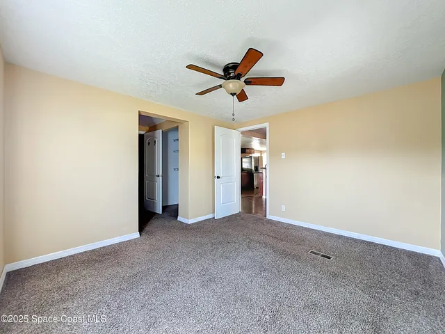 a view of a big room with closet and ceiling fan