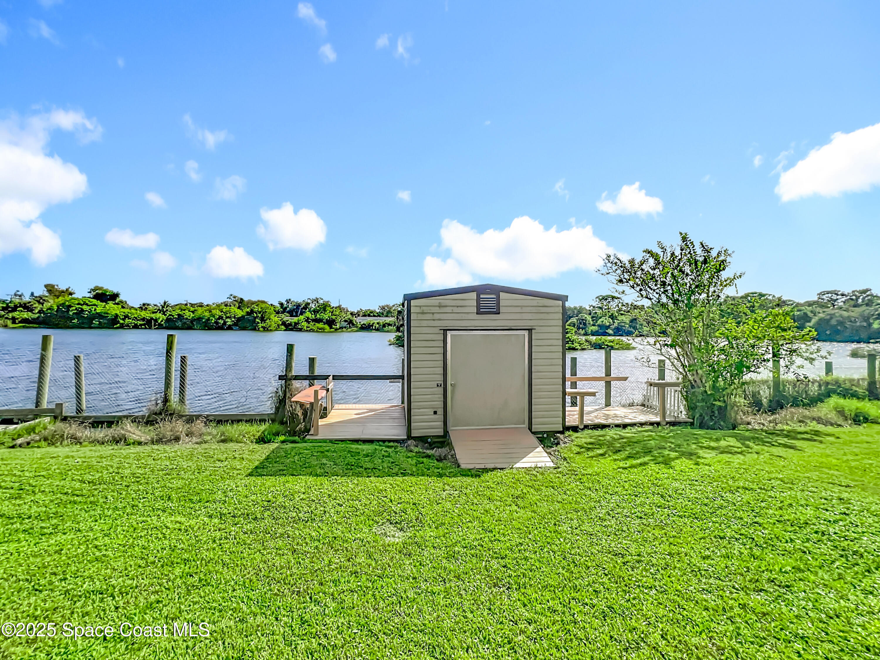 425 Baker Road Merritt Island, FL 32953 - Photo 25 of 27 a backyard of a house with lots of green space and lake view