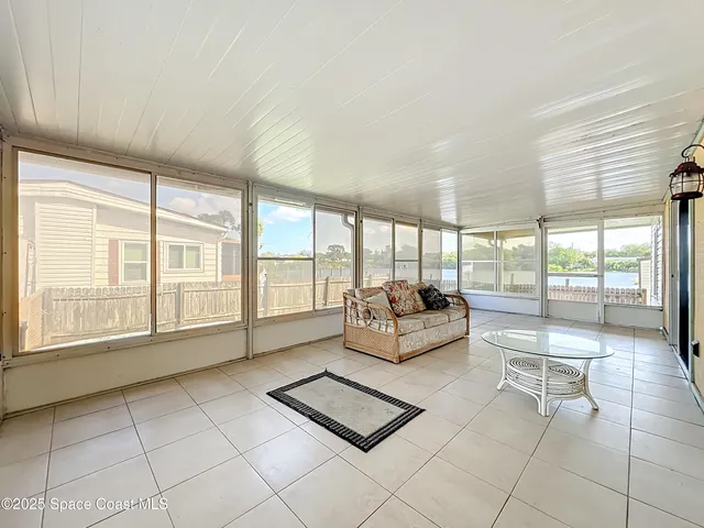 a living room with furniture and large windows