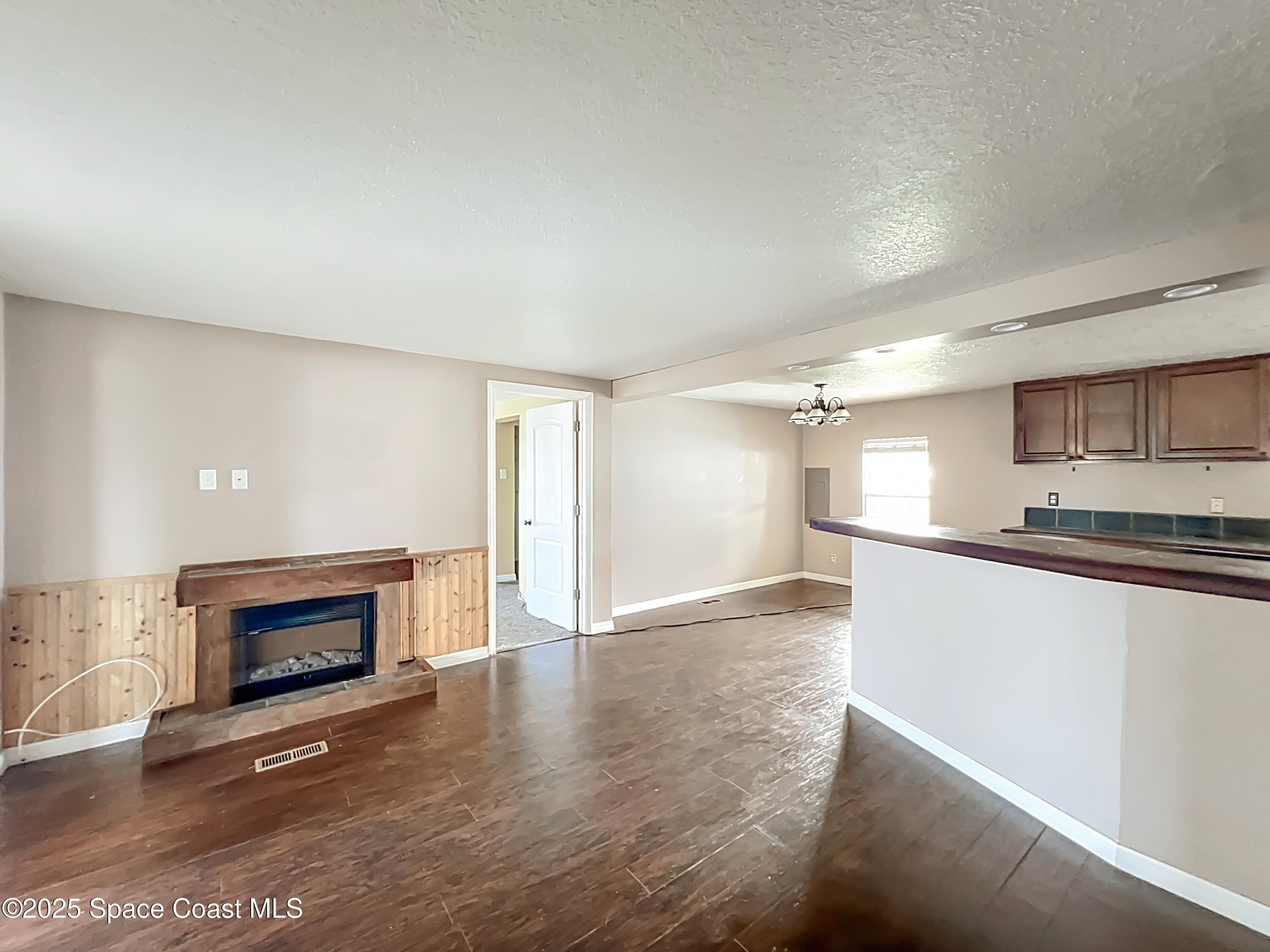 425 Baker Road Merritt Island, FL 32953 - Photo 6 of 27 a view of empty room with wooden floor and fireplace