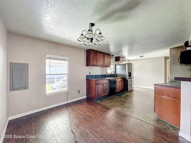 a kitchen with stainless steel appliances wooden floors and wooden cabinets