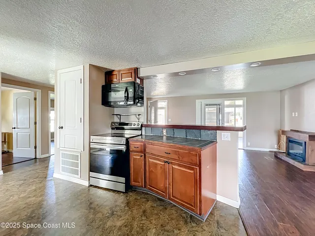 a kitchen with stainless steel appliances granite countertop a refrigerator and a stove top oven