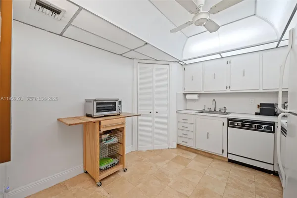 a kitchen with white cabinets and white stainless steel appliances