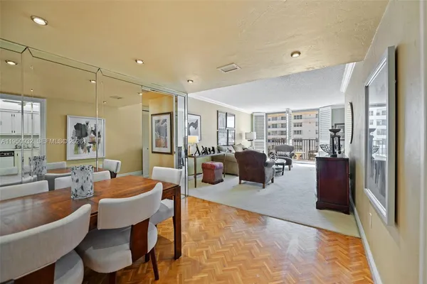 a living room with furniture large window and wooden floor