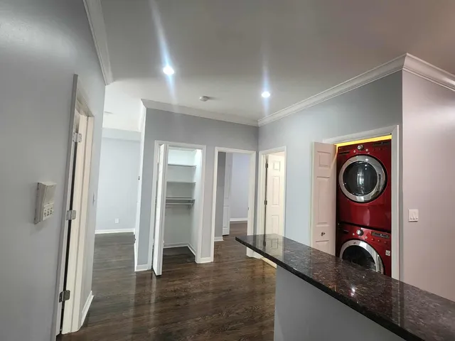a view of a hallway with wooden floor and closet
