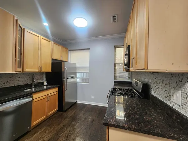 a kitchen with sink a refrigerator and cabinets