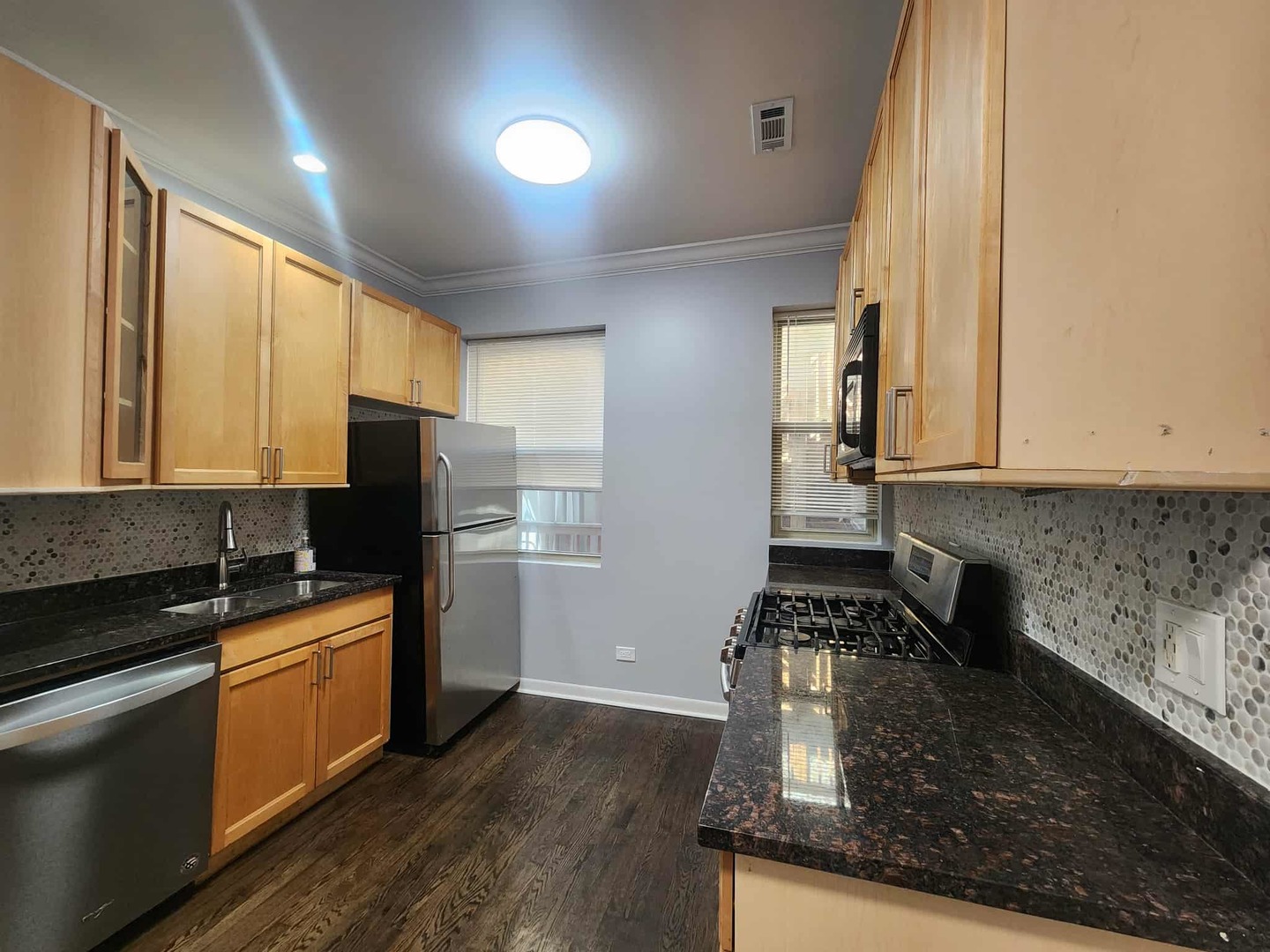 4855 North Harding Avenue, Unit 2 Chicago, IL 60625 - Photo 6 of 10 a kitchen with sink a refrigerator and cabinets