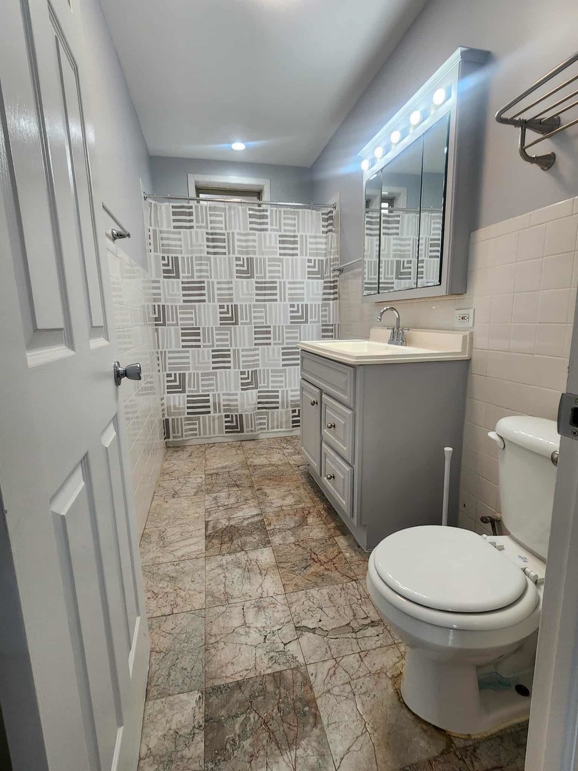 4855 North Harding Avenue, Unit 2 Chicago, IL 60625 - Photo 8 of 10 a bathroom with a toilet and a shower