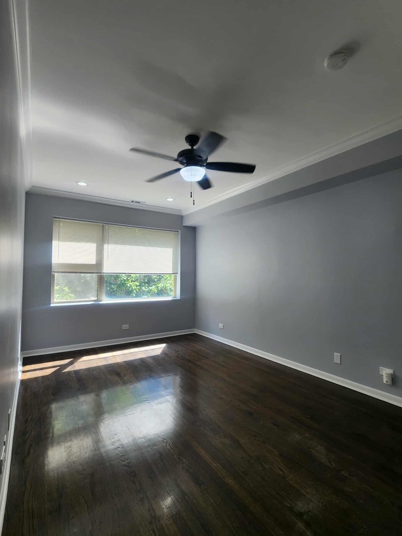 4855 North Harding Avenue, Unit 2 Chicago, IL 60625 - Photo 9 of 10 an empty room with wooden floor and windows