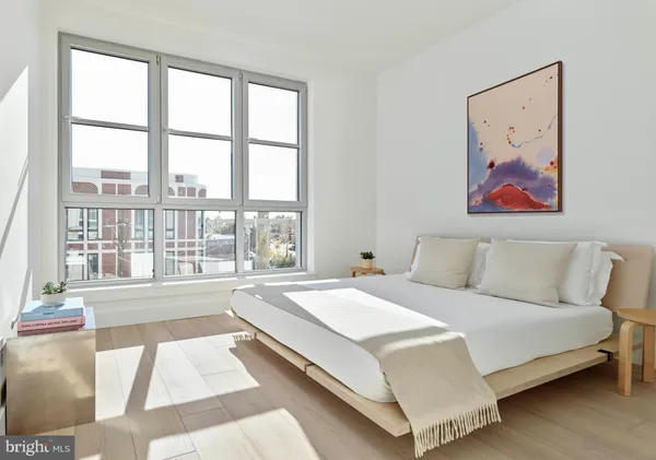 a spacious bedroom with a large bed and a large window